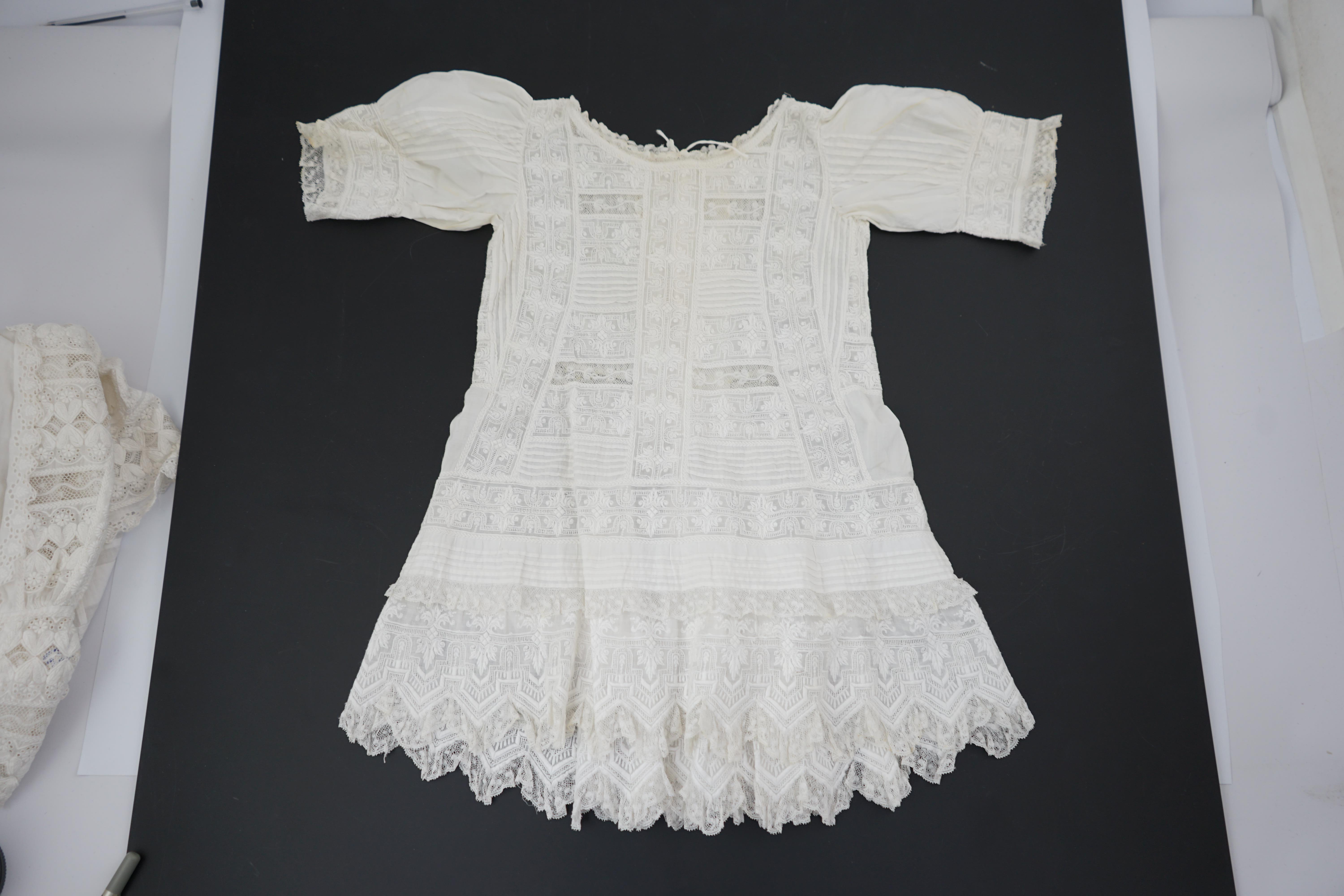 Two unusual 19th century intricately white worked children’s dresses, one hand worked with fine panels of white work, feather stitching and tucking, edged and inserted with hand made Valenciennes lace, the other worked i